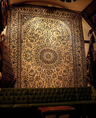 Antique Persian Area Rugs: A Tapestry of History and Art A silk Persian rug with a glowing medallion design, rich with cultural motifs. Photo by Aslı Yaren Peker