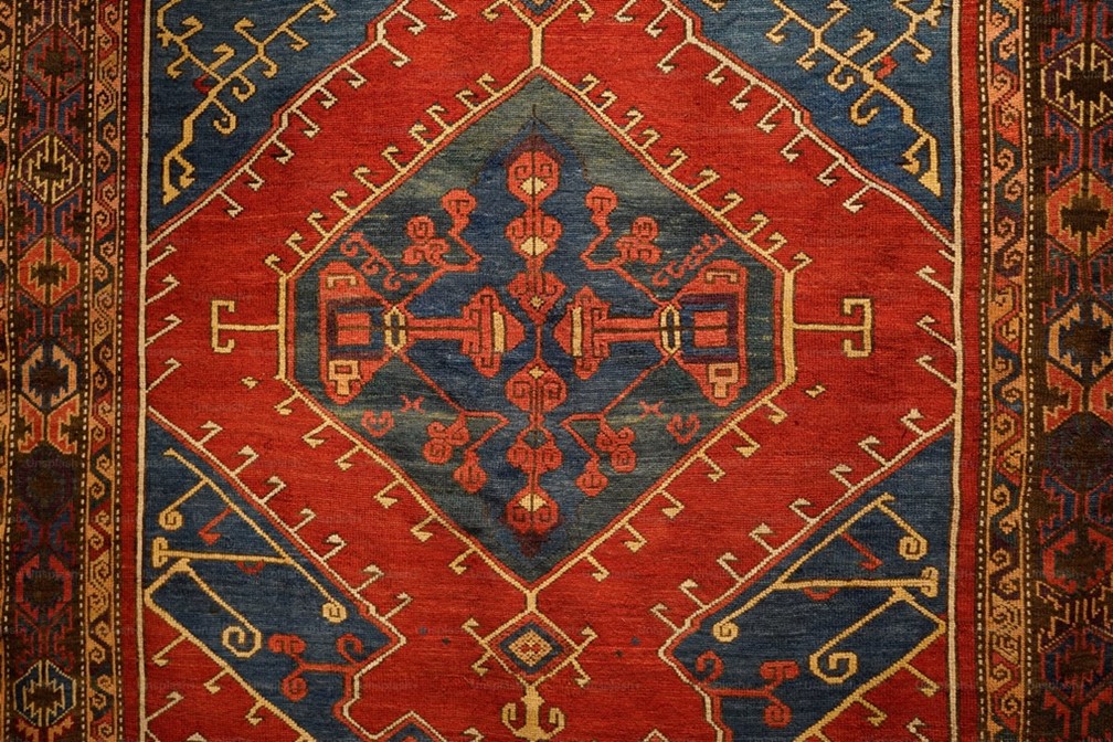 A Deep Dive into the Iconic Geometric Designs of Heriz Persian Rugs A Heriz Persian rug, a stunning red Persian rug, with a medallion design. Credit: Image courtesy of public domain, CC0.