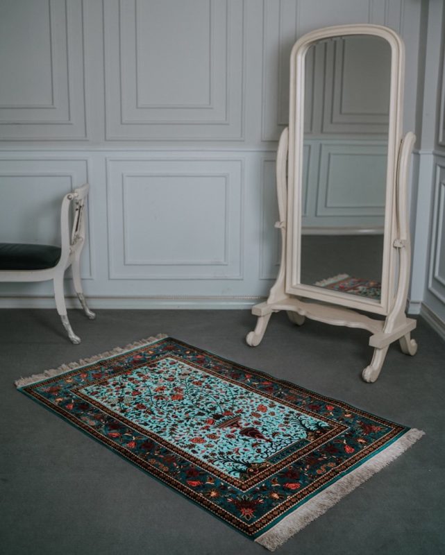 Rug vs Carpet: Why a Persian Style Rug Wins A Persian style rug layered over carpeting for added elegance.
