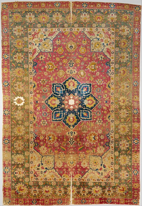 Kashan Persian Rugs A 16th-century Kashan Persian rug featuring a bold red field with a central medallion in blue and ivory, showcased at the Metropolitan Museum of Art. Image courtesy of The Metropolitan Museum of Art.