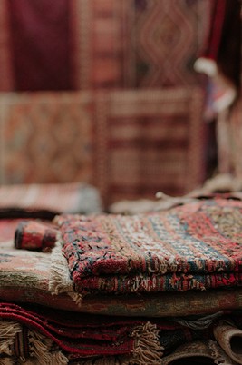 A Complete Guide to Hand Knotted Persian Style Rugs A stack of stories. These layered rugs, with their faded colors and intricate weaves, hold the history of every step they've seen. Photo by Juli Kosolapova